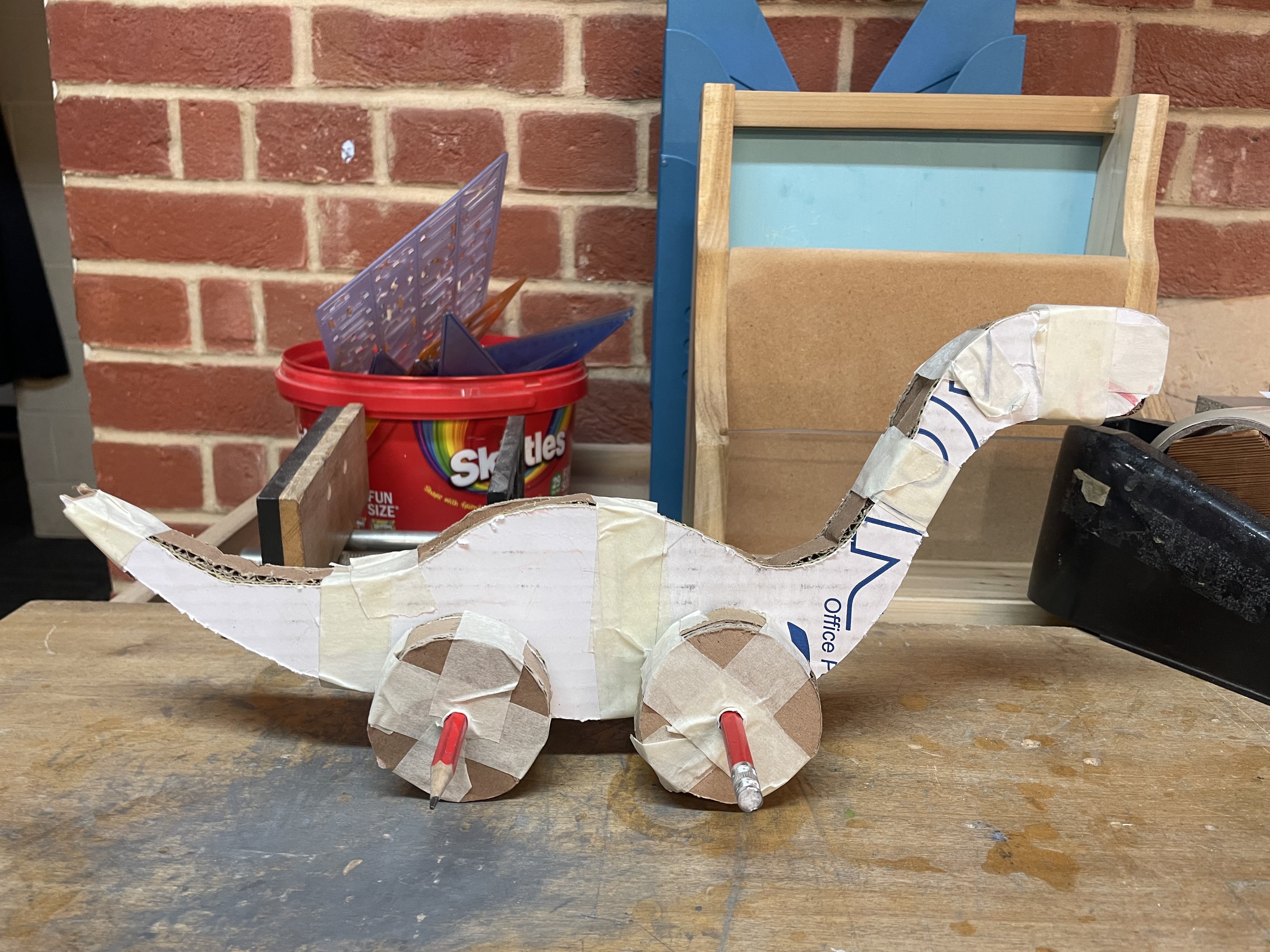 Cardboard prototype with pencil axles — early design validation
